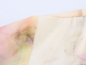 Dettaglio di pizzo sulla spalla e stampa floreale pastello su abito in chiffon leggero