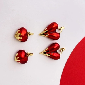 Close-up of red enamel heart-shaped pendants with gold trim for DIY jewelry