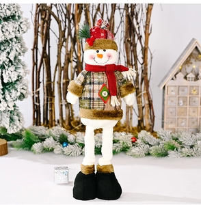 Close-up of a plush Christmas snowman with plaid clothes and red knit hat in a winter scene