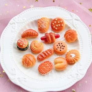 Detailed macro view of thirteen miniature resin bread and pastry models on a white plate