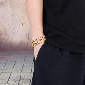 Close-up of a wide triple-row gold chain bracelet with a heavy rock hip-hop style design