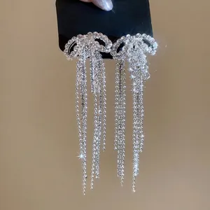Elegant silver bow earrings with long rhinestone tassels for a luxurious dangling look