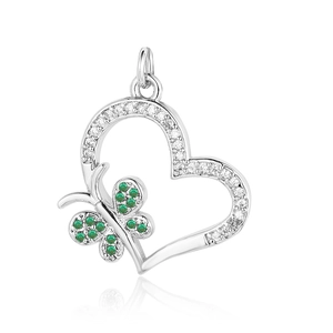 Macro shot of silver heart pendant with butterfly design and green gemstones inlay