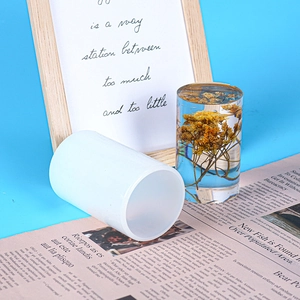 Macro shot of translucent cylindrical silicone mold with floral resin pillar artwork