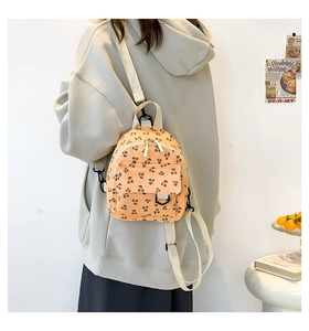 Detail view of mini corduroy backpack with cherry pattern and adjustable straps