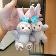 Detail of plush rabbit astronaut keychain with blue flower accessory and soft texture