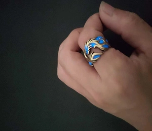 Detail of dragon pattern ring with glowing blue luminous inlay in low light conditions