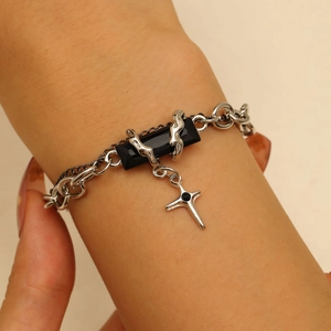 Gothic style silver fluid chain bracelet featuring a black gemstone and cross pendant