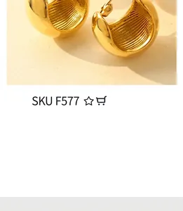 Close-up of golden C-shaped hoop earrings with internal ribbed texture and polished finish