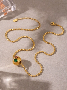 Macro d'un collier S925 doré avec pendentif sphérique orné de strass tchèques multicolores