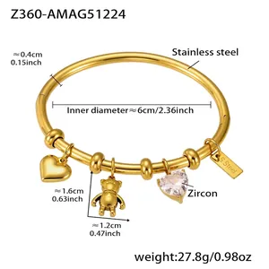 Detail view of a 18k gold-plated stainless steel bangle with heart and bear charms
