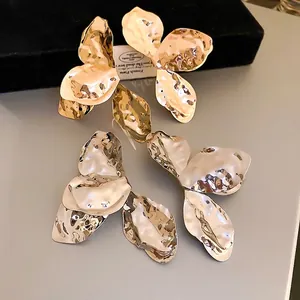 Unregelmäßige Blumenohrringe in glänzendem Gold und Silber mit gehämmerter Metallstruktur