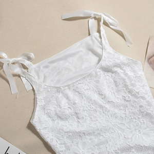 Detail of white floral lace dress featuring adjustable satin shoulder tie straps