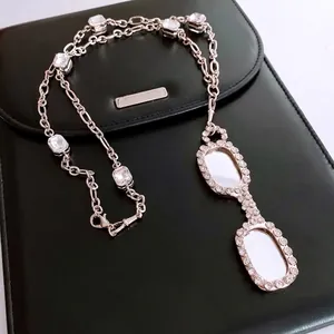 Silver eyewear pendant necklace with rectangle crystals on black leather backdrop