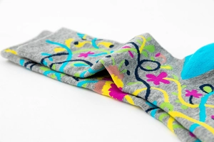 Close-up of gray knit socks with vibrant abstract floral vine patterns in multiple colors