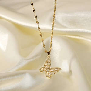 Close-up of a gold 18K butterfly pendant with white marquise zircons on silk background
