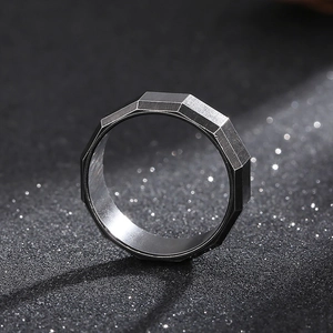 Macro detail of gunmetal gray geometric faceted ring with brushed steel texture