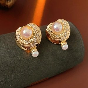 Détail de boucles d'oreilles vintage en perles dorées avec cristaux sur un présentoir