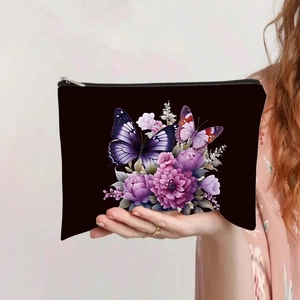 Detail of black canvas makeup bag with purple butterfly print and silver zipper