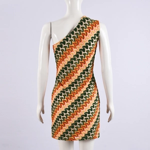 Détail du motif géométrique tricoté vert et orange sur une robe moulante à une épaule