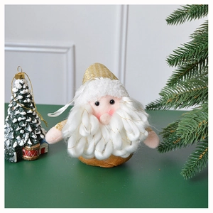Detail of Santa plush ornament with sequins on green surface with festive pine branches