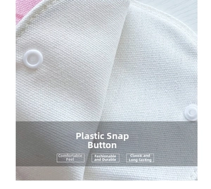 Detailed macro view of high-quality plastic snap buttons on white canvas tote bag