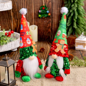 Christmas gnome plush dolls with sequin hats and gingerbread man decor on wooden table