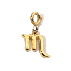 Macro shot of Scorpio zodiac pendant in gold-plated stainless steel on white background