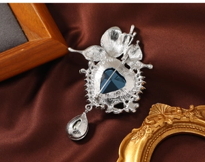 Detailed back view of vintage silver butterfly brooch with blue crystal and pear pendant