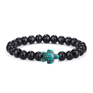 Elastic beaded bracelet featuring black glossy stones and a green turquoise turtle charm
