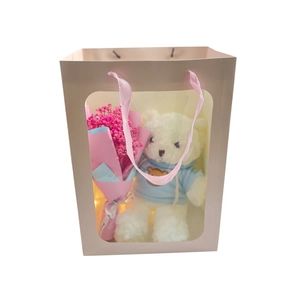 Pink paper gift bag with transparent window featuring a white plush bear and pink flowers