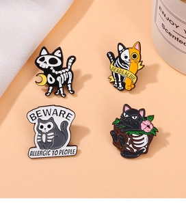 Detail of four Halloween skull cat pins featuring Dead & Alive and Beware text