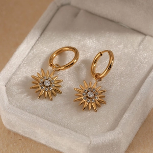 Golden sunburst earrings with clear crystals in a gray velvet jewelry gift box