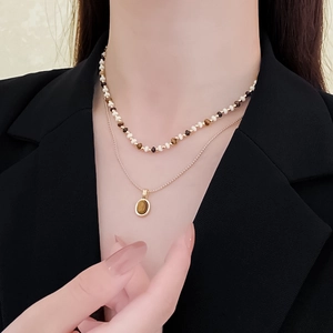 Detailed layered necklace featuring beaded short chain and oval tiger eye stone pendant