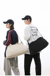 Large capacity lightweight travel duffel bag shown on male and female models.