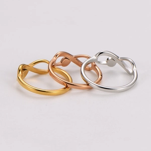Detailed view of infinity symbol rings in gold, rose gold, and silver finishes