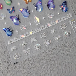 Holographic 3D nail art stickers with blue butterflies, lace flowers and pearl accents