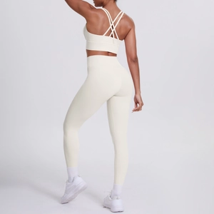 Détail de la brassière croisée et du legging taille haute de l'ensemble yoga crème