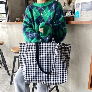 Detailed view of the gingham canvas tote bag showing the textured fabric and strap