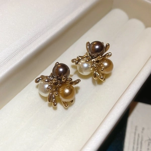 Detailed macro view of retro brown and white pearl studs with golden metal frames