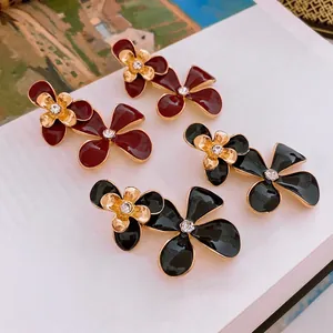 Vintage floral stud earrings with red and black enamel petals and crystal centers