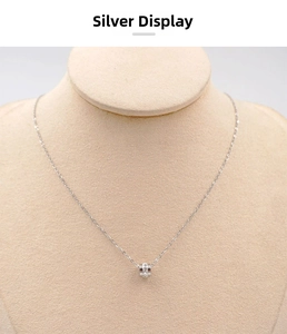 Close-up of silver cylinder pendant necklace with sparkling crystals on a jewelry display
