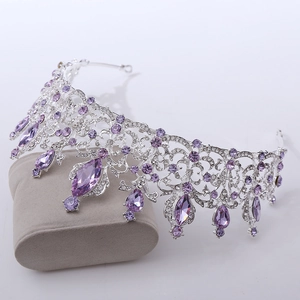 Detail of luxury silver bridal crown with purple crystals on a gray display pillow