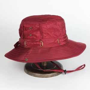 Detail of red wide-brim sun hat with metallic vents and adjustable wind drawstring