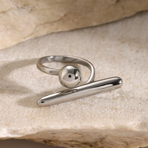 Makro-Detail des silbernen geometrischen Rings mit polierter Perle auf Naturstein