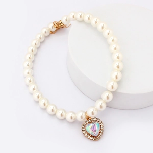 Detail of pet pearl collar featuring a sparkling AB crystal heart pendant and gold clasp