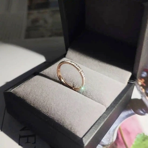 Detailed view of a rose gold titanium steel ring with a single row of diamonds in a box.