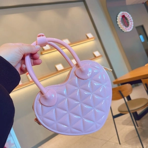 Detail of pink heart-shaped PVC jelly bag with quilted diamond pattern texture