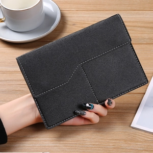 Detailed macro view of black faux leather storage pouch with white stitching and litchi texture