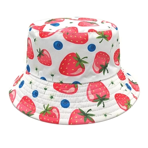 Detailed close-up of a white bucket hat featuring cute red strawberry and blueberry prints